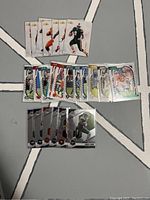 Photo showing 24 NFL football cards arranged in three rows on a flat surface, with a variety of series including 6 Mosaic, 11 Absolute, 7 Football7, and some Wild Card Matte cards.
