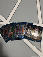 Photo displaying 12 2021 Select NBA basketball cards fanned out on the floor, showing player images and card design.