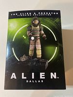 Front view of the Alien Dallas figure box showing the figurine image and series name.