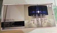 Box packaging showing brand, measurements, and design of the pendant light chandelier with black shade and crystal-like beads.