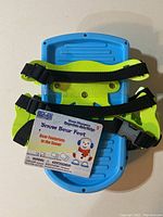 Snow Bear Feet snow stampers blue and neon green with black straps and product label attached