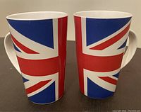 Front view of two ceramic mugs decorated with Union Jack flag design, showing exterior pattern and large handles.