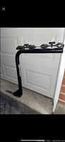 Full side view of the black Sportrack bike rack showing four cradles for bikes and vertical support.