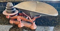 Side angle showing vintage mechanical counter scale with weights arranged on pan