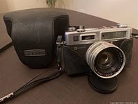 Yashica Electro 35 film camera with case on table, camera front and case visible