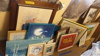 Overview of most wall art pieces grouped on floor, showing varied framed and unframed pieces of different sizes.