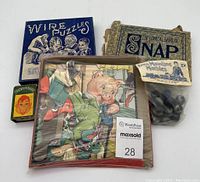 Lot showing unopened Ives Mainline marbles in plastic bag with label, Howdy Doody game cards box, wire puzzles box, The Game of Snap card game, and two picture puzzles.