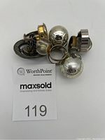 Top view of all 6 rings showing varied designs and metals - silver, gold tones, spherical and geometric shapes.