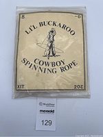 Original plastic bag with a cream label reading 'Lil Buckaroo Cowboy Spinning Rope' and a cowboy illustration.