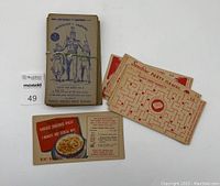 A group photo with a bundle of the Straight Arrow Nabisco Shredded Wheat cards tied with a rubber band, Sunshine Party Game maze cards, and a Nabisco Shredded Wheat recipe card.