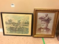 Photo showing both framed prints leaning against a wall, the Block House scene on left and the woman's portrait on right