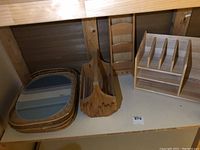 Four wooden trays, a wooden basket, a mail holder, and a desk organizer grouped on a shelf