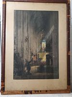 Framed engraving of cathedral interior with visible signs of frame wear and discoloration around mat.