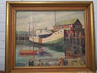 Framed oil painting showing a harbor with boats and a building. Damage on canvas is visible near the lower center region.
