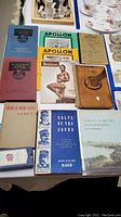 Photo of arranged vintage books and magazines on a table, including bodybuilding magazines, Rhode Island history books, poetry book, and telephone directory.