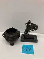 Photo showing both the vintage bronze candle holder with bird detail and the Frederic Remington signed cowboy on horseback statue on a marble base.
