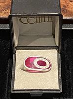 Silver ring with oval pink enamel top, rhinestone detail, in its box