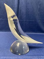 Side angle of white and transparent Murano glass sculpture with pointed top on clear glass base