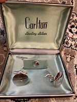 View of vintage Carlton sterling silver boxed set with pair of cufflinks and tie pin inside, showing satin-lined interior and brand name printed on lid.