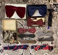 Full lot of vintage bowties, necktie and suspenders arranged on patterned carpet