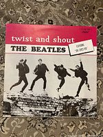 Front cover of the Twist and Shout Beatles vinyl album showing the band jumping and text