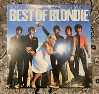 Front cover of the album featuring band members against a blue sky background with album title