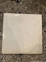 Front of the vintage white album cover with embossed text
