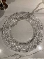 Top view of clear glass plate with bamboo lattice design around rim, showing overall size and shape on white marble surface.