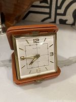 Front view of the Westclox travel clock showing the square dial with gold-tone numerals and hands, encased in a brass frame with clear "Westclox" branding and 7 jewels indication.