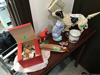 Overall lot of animal figurines including dog doorstop, hand painted cat, ceramic cat dish, resin cardinal, plastic duck, stone birds, and creamer pieces