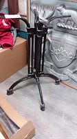 Full view of black cast iron table base with four legs and central column showing overall structure and condition.