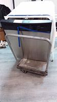 Dishwasher on metal cart with handle, showing front and side of dishwasher.