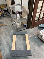 Wide view showing both the dolly and stainless steel cart, highlighting their size and condition.