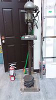 Full front view of drill press showing base, column, worktable, and head assembly.