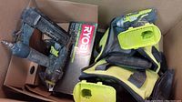 Photo showing multiple Ryobi cordless drills and tool bags inside a cardboard box