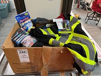 Box showing contents including a high-visibility safety t-shirt, safety glasses in packaging, various gloves, and unopened Spontex disposable gloves.