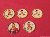Five metal 1962-63 Shirriff hockey coins showing portraits of All Star players including Jacques Plante, Dave Keon, Phil Goyette, Doug Harvey