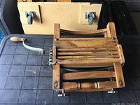 Overall view of antique wringer washer showing wooden rollers in frame and metal crank handle.