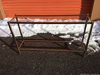 Full side perspective showing entire brass frame and glass top table.