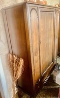 Angled side view of wooden dining cabinet showing the side panel and edge detail