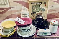 Photo of platters, bowls, plates stacked and Party Hostess Set box with serving dishes on counter