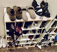 Multiple ladies shoes arranged on and around a white cubby shoe stand. Shoes are in various styles and colors, including heels, sandals, and casual shoes.
