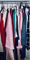 Closet rod with multiple hanging robes, gowns, and lounge wear garments in various colors and textures.