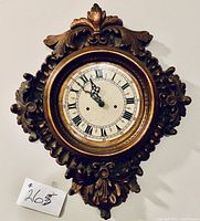 Ornate wood wall clock with decorative frame and Roman numeral face, clock not working