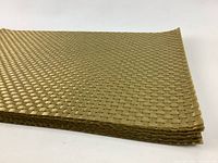 Close-up view of the stacked gold woven nylon placemats showing the edge and texture of the weave.
