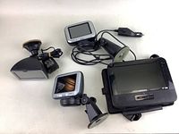 Group of three automotive tech devices: two GPS/navigation units and one Philips portable DVD player