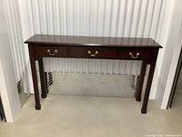 Front view of the solid wood front entrance table showing three drawers and brass pulls.