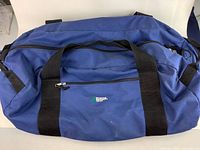 Full view of blue MEC duffel bag showing overall shape and two black carry handles.