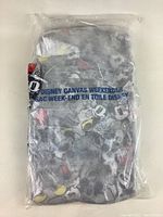 Photo of Disney canvas weekender bag sealed in plastic packaging showing Mickey Mouse graphic and product text.