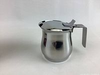 Stainless steel espresso maker showing the full item with handle and lid in a neutral background.